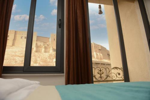 a bedroom with a window with a view of a castle at Syros Hotel Erbil City Center in Erbil