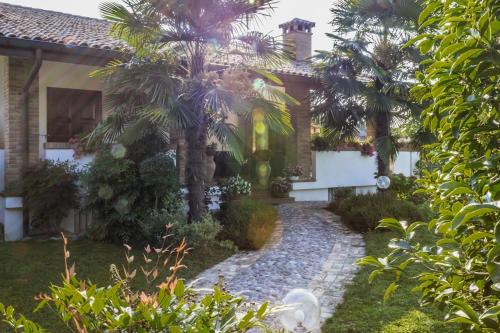 une maison avec des palmiers devant elle dans l'établissement Ca' Livenza, à Sacile