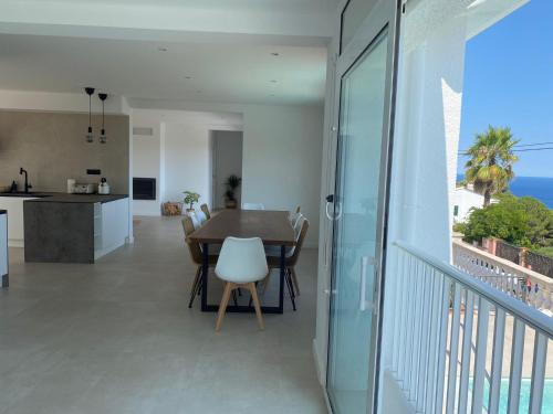 a dining room and kitchen with a view of the ocean at Villa Casa Blanca in Blanes