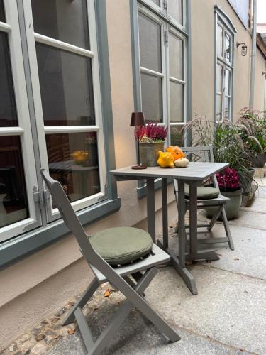 une chaise, une table, une table et des chaises sur une terrasse dans l'établissement Warnemünde: Apartment KAJÜTE - nur 3 Gehminuten zum Strand, à Warnemünde