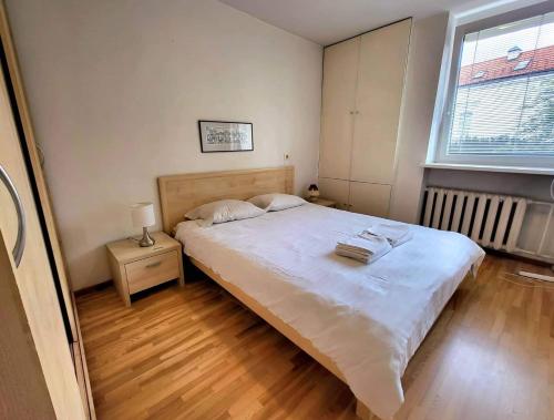 a bedroom with a large white bed and a window at Stasys Apartments Pilies Street in Vilnius