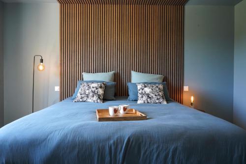 Una cama con una bandeja con dos velas. en La maison en Provence, en Graveson