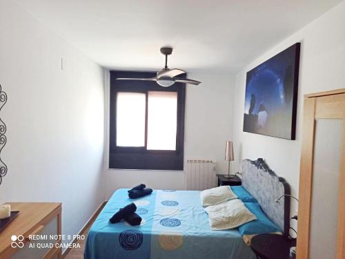 a bedroom with a blue bed and a window at Apartamento Deltebre in Deltebre