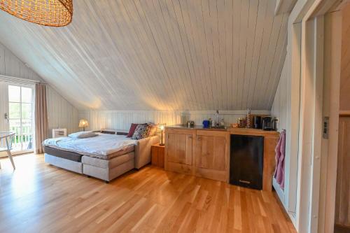 a bedroom with a bed and a wooden floor at Nyhagens trädgård och B&B in Berghem