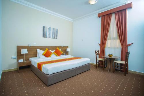 فندق لا فيلا في الدوحة: غرفة نوم مع سرير كبير مع وسائد برتقالية برتقالية