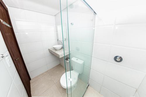 a bathroom with a glass shower with a toilet at Pousada Maanaim Porto in Porto De Galinhas