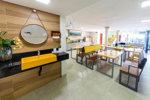 a restaurant with a yellow sink and a yellow mirror at Pousada Maanaim Porto in Porto De Galinhas
