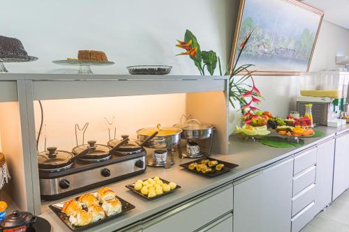 a kitchen with a stove with food on it at Pousada Maanaim Porto in Porto De Galinhas