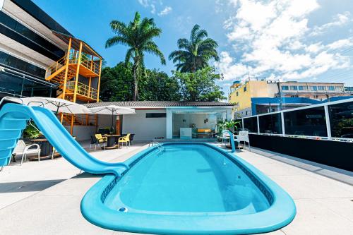 a swimming pool with a slide on a building at Pousada Maanaim Porto in Porto De Galinhas