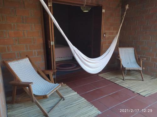 two chairs and a hammock on a porch at Hotel Bendita Luna in Mazunte