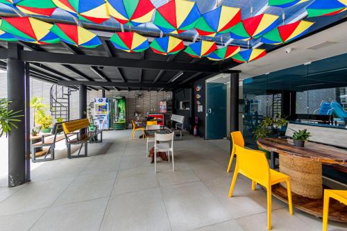 a room with chairs and tables and a colorful ceiling at Pousada Maanaim Porto in Porto De Galinhas