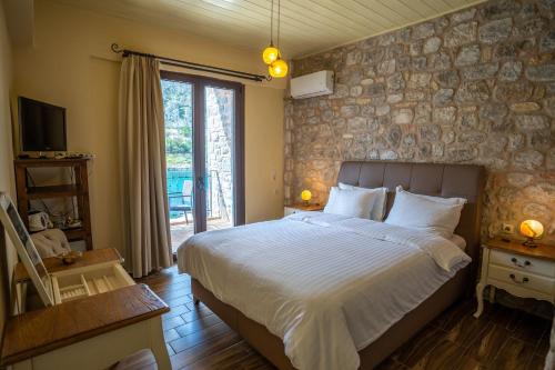 a bedroom with a large bed and a stone wall at Guesthouse Laoula in Gerolimenas