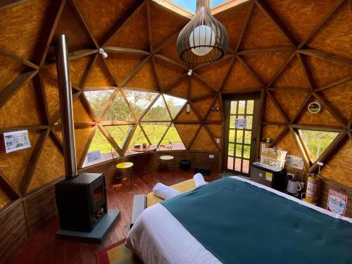 a large room with a bed and a tv in it at Voces de Aves Glamping in Chocontá