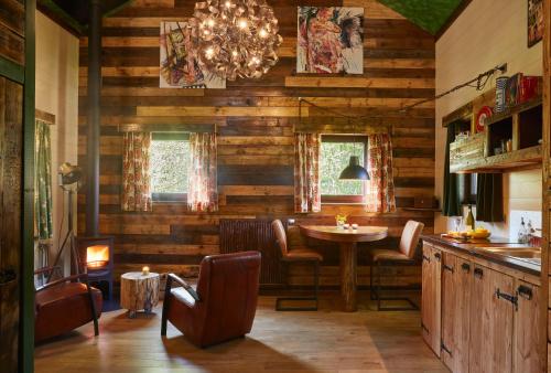 a dining room with a table and a chandelier at Chalet Mont Juru - Rust, Romantiek & Ruimte voor 2 Volwassenen op privé domein in Houffalize