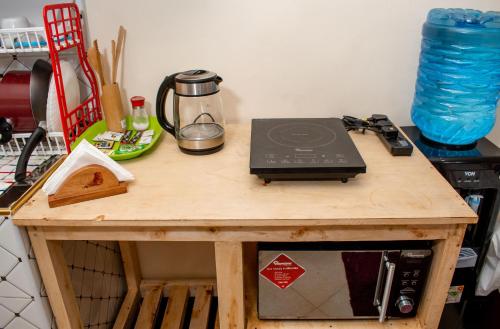 a wooden table with a microwave on top of it at Nelly fully furnished studios in Naivasha