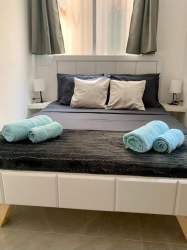Una cama grande con almohadas azules encima. en New 2 rooms flat fully equipped 5 min to Bat Yam beach near Tel Aviv, en Bat Yam
