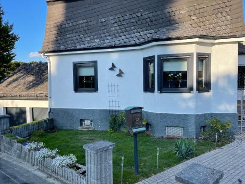 Biały dom z czarnymi oknami i dziedzińcem w obiekcie Anil‘s Ferienhaus w mieście Olsberg