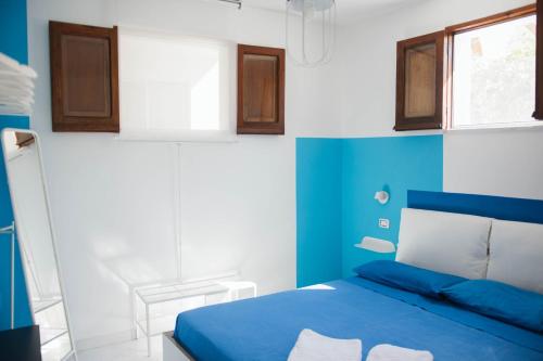 a blue and white bedroom with a bed and a window at Casa aMmare in Pioppi