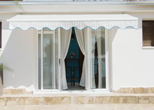 a white building with a window with curtains at Casa aMmare in Pioppi