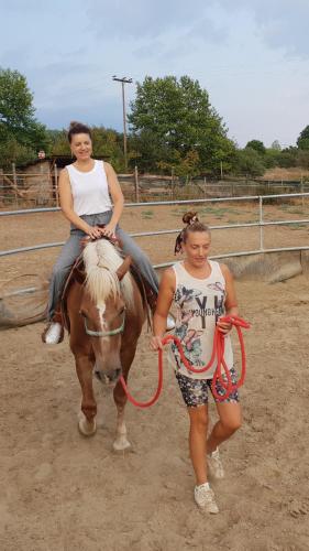two girls are riding a horse with a woman on it at Mondeus Inn Luxury in Deskáti