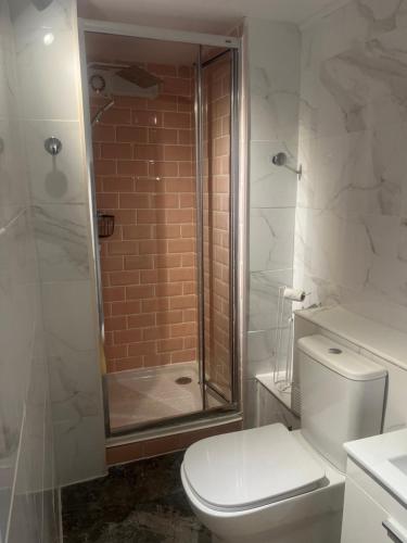 La salle de bains blanche est pourvue d'une douche et de toilettes. dans l'établissement Dos Senoras Gordas, à Relleu