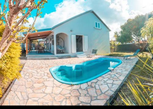 una casa con una piscina blu di fronte a una casa di VILLA SANTIBANEZ - Villa avec piscine à St André a Le Patelin