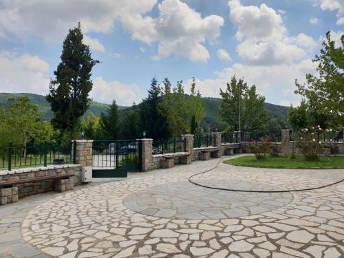 a stone walkway with benches in a park at Mondeus Inn Luxury in Deskáti