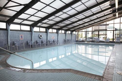 a large swimming pool with chairs in a building at The Barclay Towers Hotel and Resort in Virginia Beach