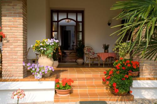 a porch with pots of flowers in front of a house at Ca' Livenza in Sacile