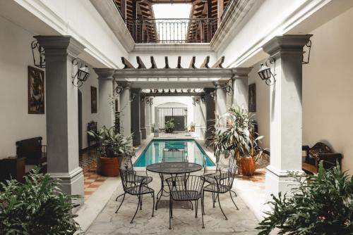 uma piscina interior com uma mesa e cadeiras num edifício em Hotel & Restaurante La Gran Francia em Granada