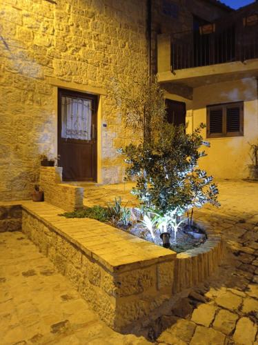 a building with a tree in front of a building at Casa Vacanze Borgo Gulini da Anna in Petralia Soprana