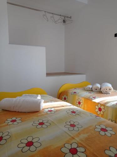 a room with two beds with flowers on them at Casa Vacanze Borgo Gulini da Anna in Petralia Soprana