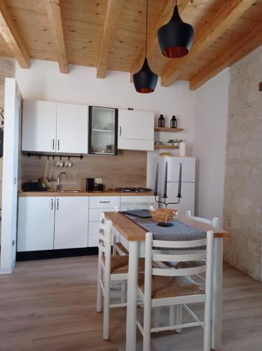 a kitchen with white cabinets and a table with chairs at Casa Vacanze Borgo Gulini da Anna in Petralia Soprana