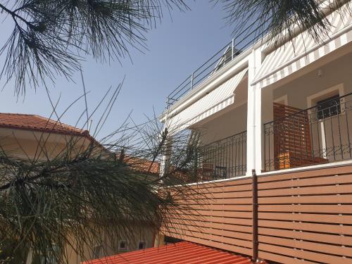 a house with a fence and a palm tree at Mondeus Inn Luxury in Deskáti