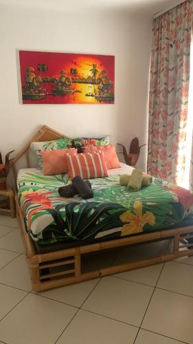 a bedroom with a bed with a colorful blanket at COULEURS DES ILES , Fréjus-plage in Fréjus