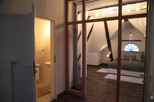 Wunderschöne Dachgeschoss - Maisonette (108qm - 3.OG) في روستوك: غرفة بسرير وباب زجاجي