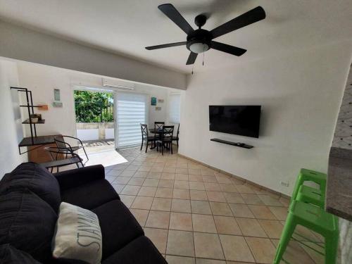 a living room with a couch and a ceiling fan at Lovely 1-Bedroom Condo with Pool, walking distance to the beach in Sosúa