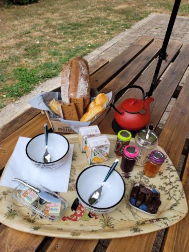 ein Tisch mit zwei Tellern mit Essen und einem Korb mit Brot in der Unterkunft Prince des carrés in Saint-Malo-en-Douziois