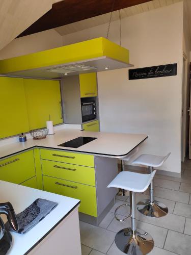 Appartement Boutx في Boutx: مطبخ به دواليب صفراء وأخضر ومكتب