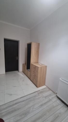 a room with a white wall and a tv and a door at Hotel Giorgi in Tskaltubo