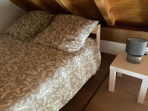 Cama pequeña en habitación pequeña con mesa en Charmante maisonnette indépendante en Broye