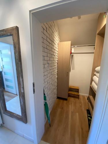 a room with a brick wall and a mirror at Apartament Chleb i Wino in Krynica Zdrój