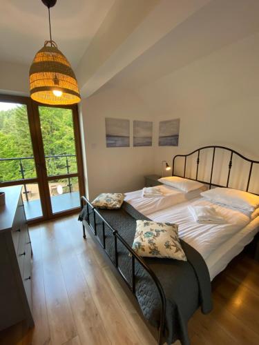 sypialnia z dużym łóżkiem i dużym oknem w obiekcie Apartament Chleb i Wino w mieście Krynica Zdrój