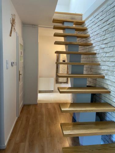 a staircase in a room with a brick wall at Apartament Chleb i Wino in Krynica Zdrój