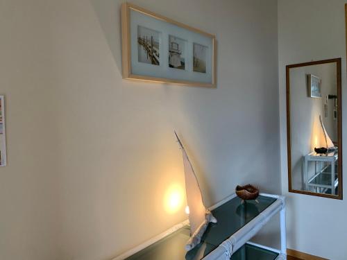 a room with a glass table and a mirror at Sunset Apartment in Santa Marinella