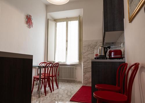 a kitchen with red chairs and a table at TimeRoma in Rome