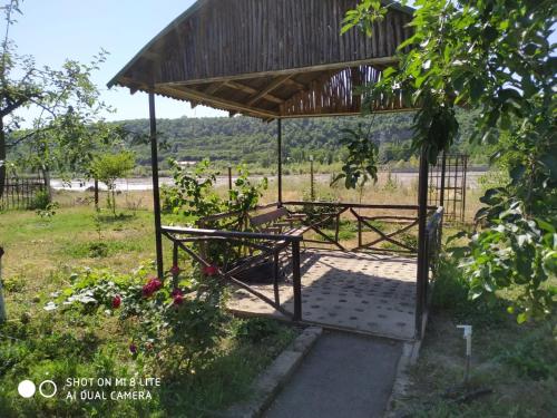 a gazebo with a roof on a field at Riverside villa in Qusar