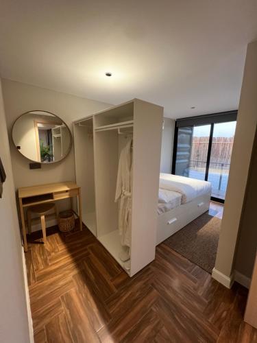 a small bedroom with a bed and a mirror at The Hidden Lodge in Al Ain