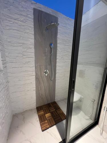 a shower with a glass door in a bathroom at The Hidden Lodge in Al Ain