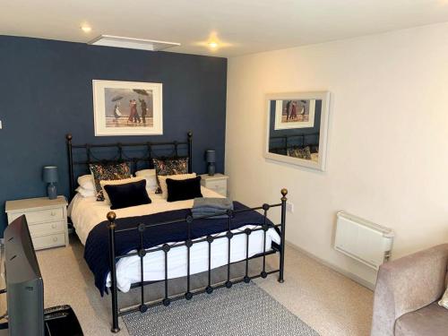 a bedroom with a bed with blue walls at Yew Tree View in Marnhull